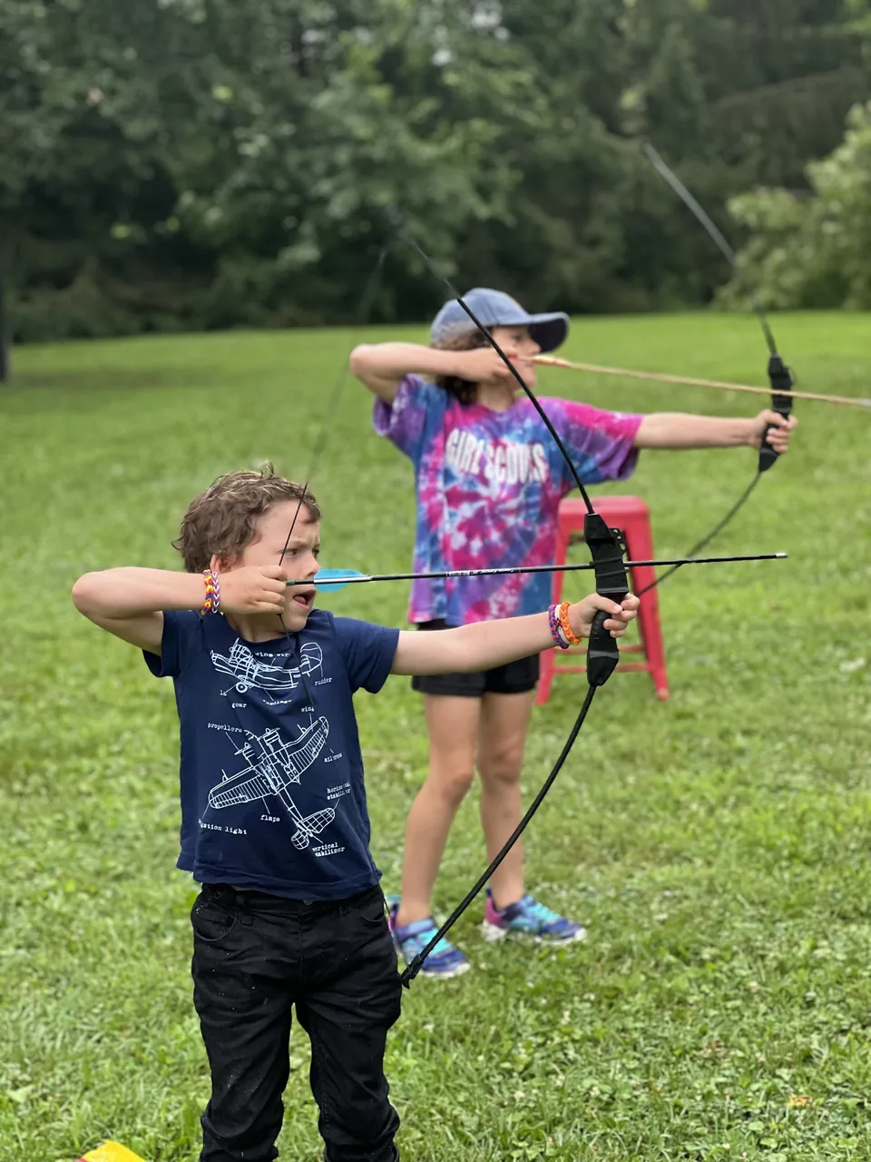 Campers practicing archery on the farm lawn