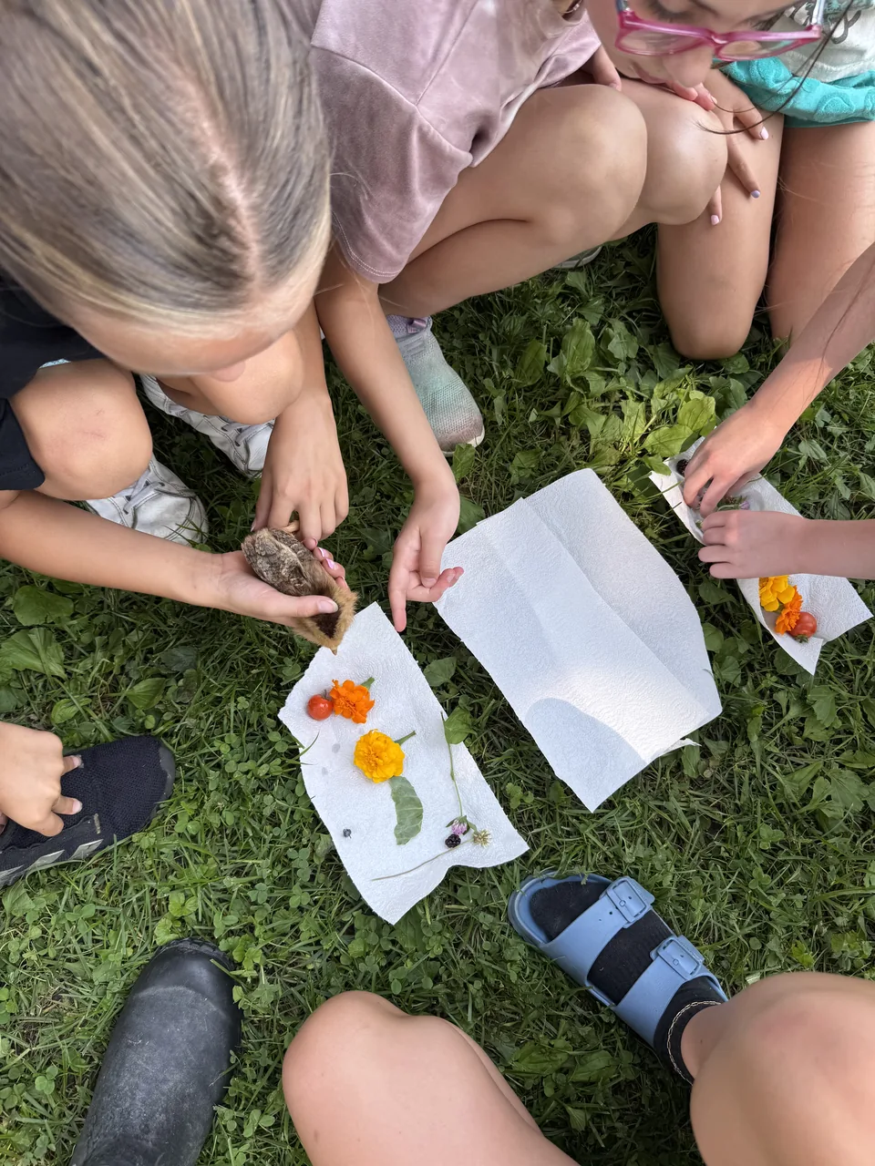 Kids pressing flowers onto paper during a nature craft